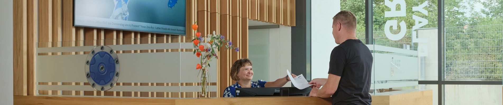 welcome area with lady at the reception desk and visitor